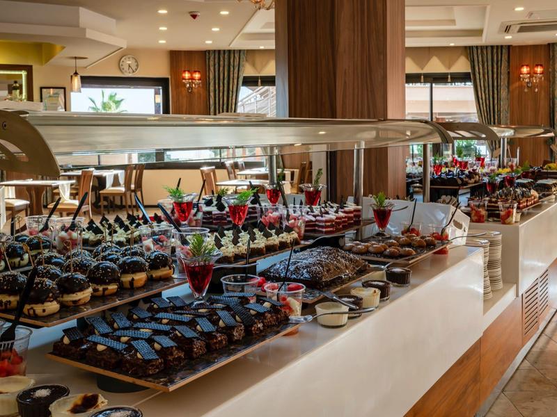 Buffet area with desserts and drinks arranged on long counters in a restaurant setting.