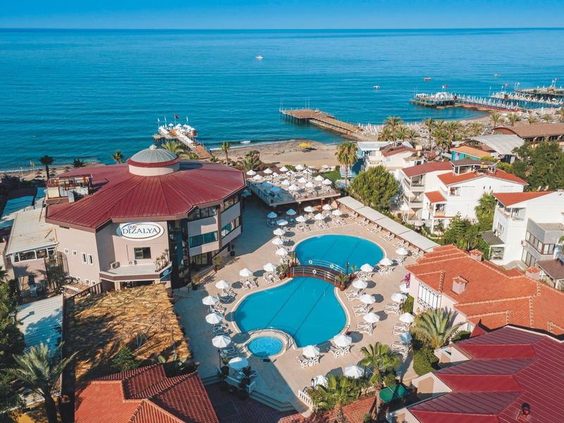 Holiday resort with multiple pools, sun umbrellas, and sea view