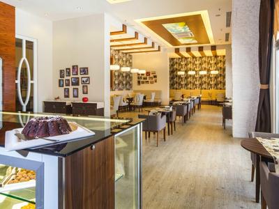 Ein modern eingerichtetes Café mit Holzboden, gemütlichen Tischen und Kuchen auf der Theke.