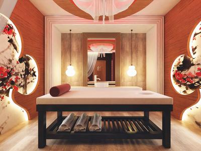 Elegancki stół do masażu w ciepło oświetlonym pokoju z dekoracyjnymi wzorami kwiatowymi na ścianach.