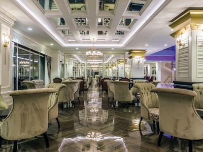 Elegancka jadalnia z aksamitnymi krzesłami, lustrami i żyrandolami w hotelu