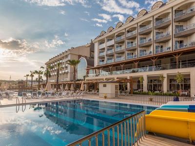 Hôtel avec piscine extérieure, transats et vue sur le coucher de soleil