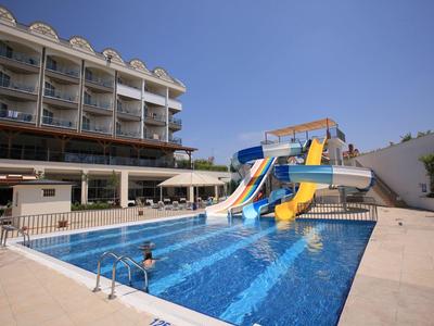 Basen hotelowy z zjeżdżalniami wodnymi i przylegającym wielopiętrowym budynkiem hotelu pod czystym niebem.