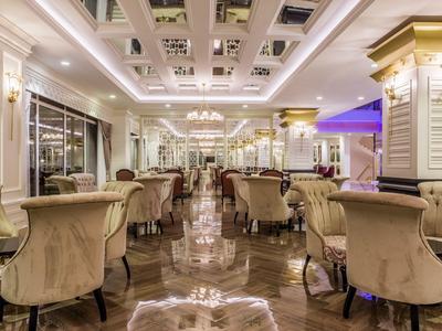 Sala da pranzo elegante dell'hotel con poltrone morbide e pavimento in marmo lucido.