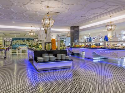 Area buffet di un hotel moderno con illuminazione elegante e varie opzioni di cibo.