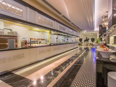 Area pranzo moderna in hotel con buffet, illuminazione elegante e design raffinato.