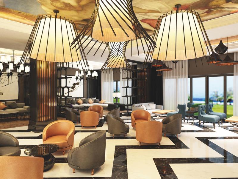 Nowoczesna część wypoczynkowa hotelu z wygodnymi miejscami do siedzenia i stylowymi lampami.