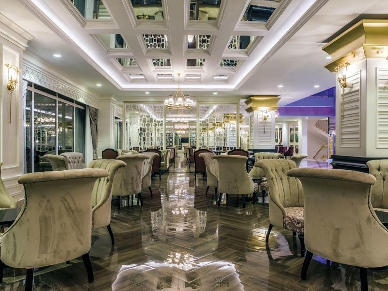 Elegancka jadalnia z aksamitnymi krzesłami, lustrami i żyrandolami w hotelu