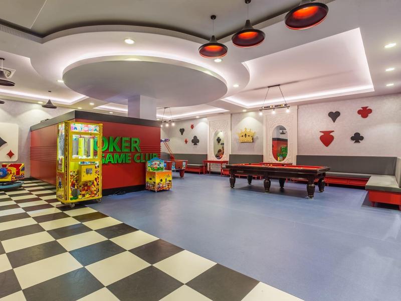 Jasny pokój gier z skee-ballem i automatami w hotelu.