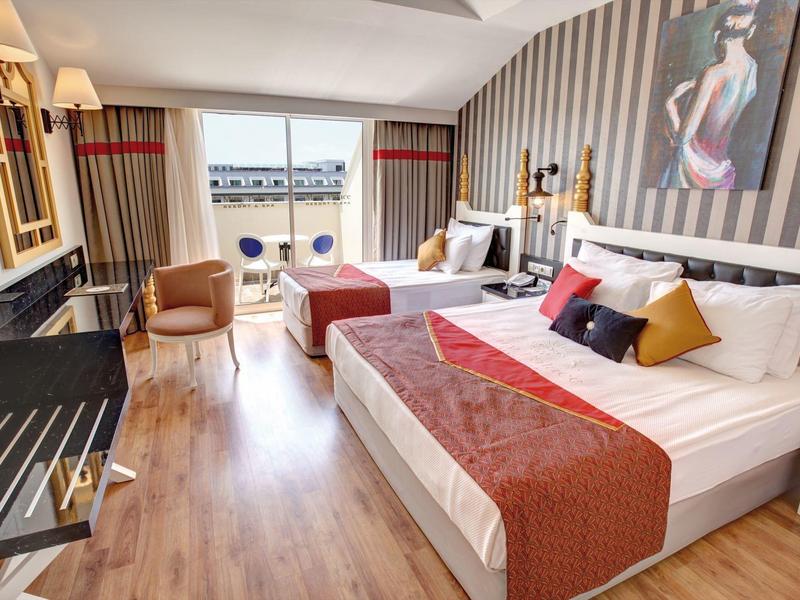 Nowoczesny pokój hotelowy z podwójnym łóżkiem, miejscem do siedzenia i dużym oknem z widokiem na wodę.