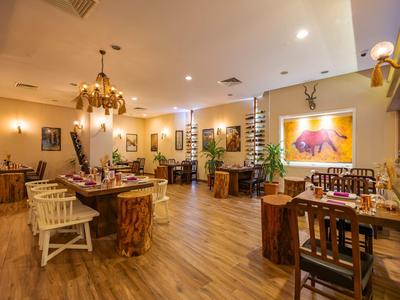 Acogedora sala de comedor con muebles de madera, luz cálida y elementos decorativos para visitantes.