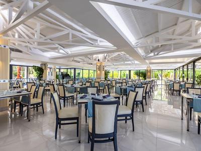 Ampia e luminosa sala da pranzo dell'hotel con design moderno e molti tavoli e sedie.