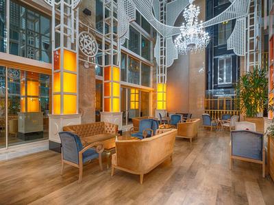 Spacious hotel lobby with elegant seating, large windows, and warm lighting.