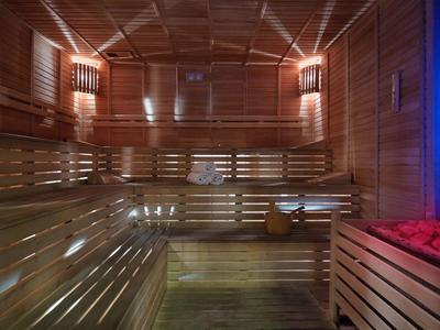 Houten sauna interieur met banken en warme verlichting, voor een ontspannende sfeer.