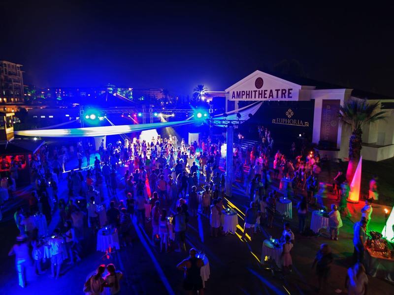 Nachtfeest bij het zwembad met kleurrijke lichten en veel mensen die van het evenement genieten.