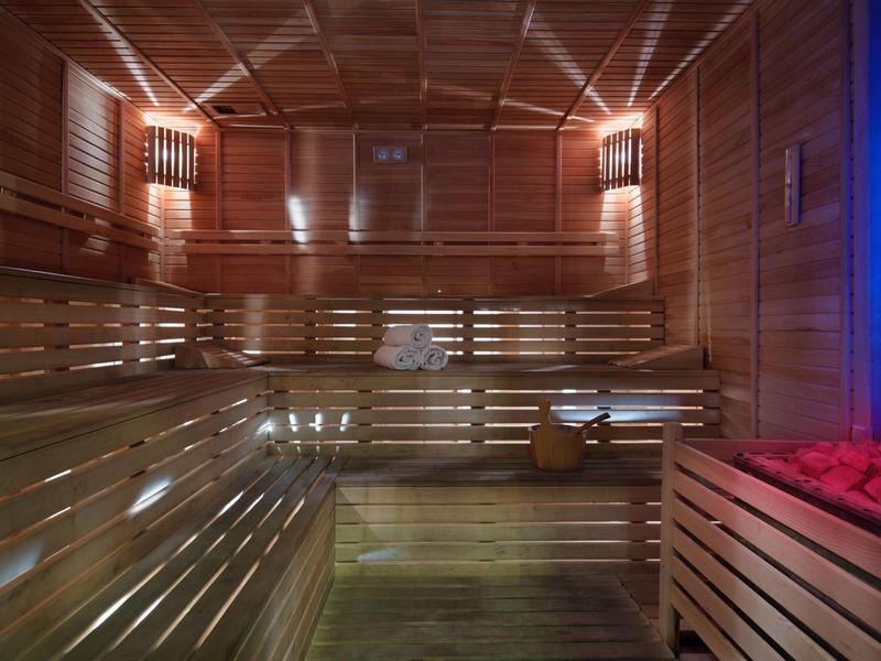 Houten sauna interieur met banken en warme verlichting, voor een ontspannende sfeer.