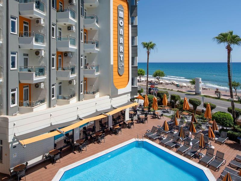 Hotel met buitenzwembad, ligstoelen en zeezicht op een zonnige dag