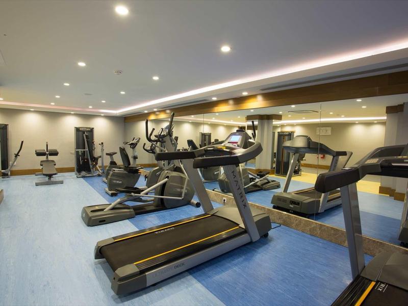 Salle de sport moderne avec tapis roulants et équipements de fitness.