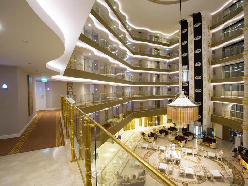 Intérieur d'un hôtel moderne avec balcon doré et espace détente lumineux.