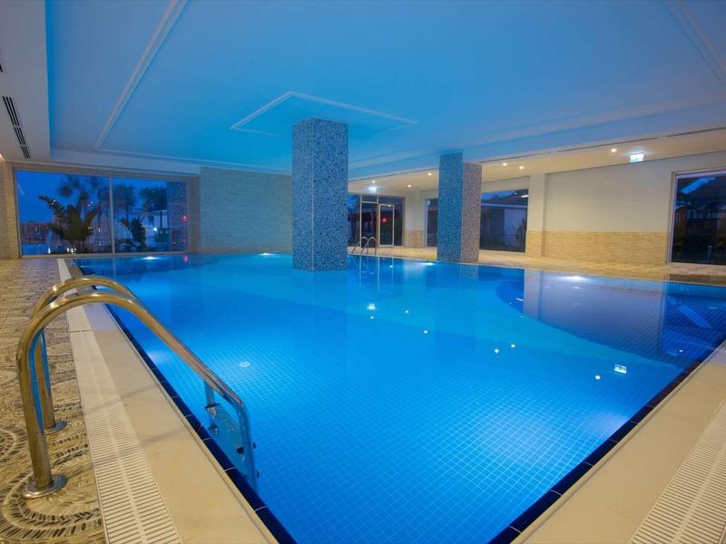 Piscine intérieure éclairée avec eau calme et rampes d'accès