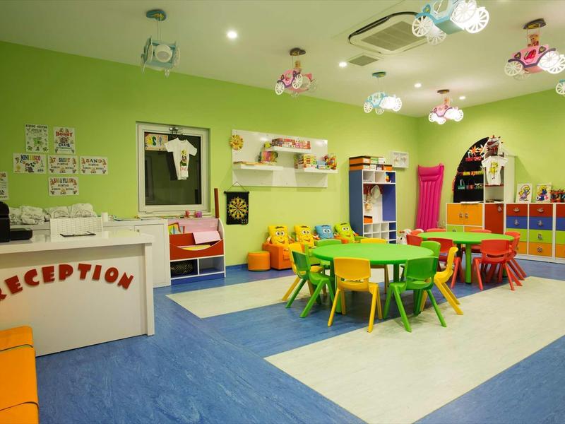 Salle d'accueil colorée avec espace enfant et mobilier lumineux.
