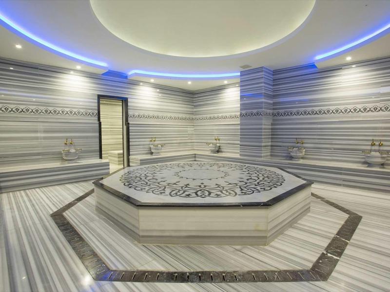 Intérieur d'un hammam luxueux avec une grande plateforme centrale ornée.