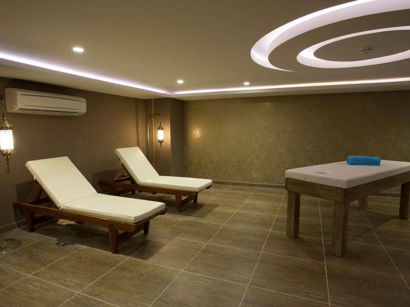 Salle de relaxation avec deux chaises longues et une table de massage.