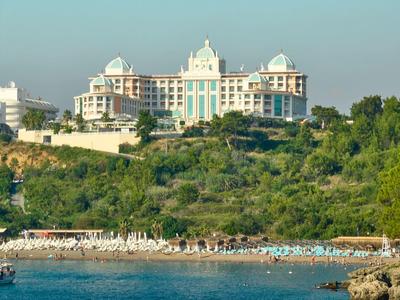 Luxury hotel on a wooded hill overlooking a pebble beach and the sea
