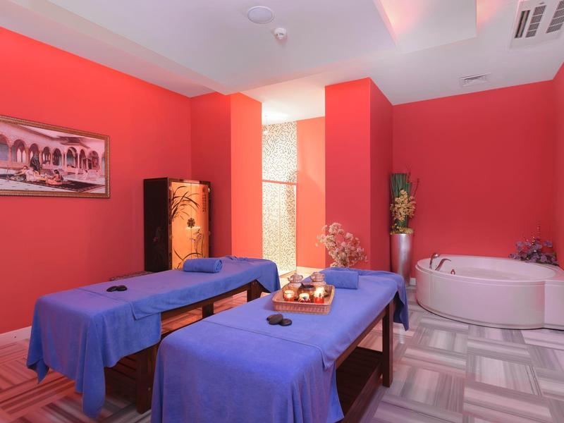 Relaxation room with two massage tables, whirlpool, and red walls.