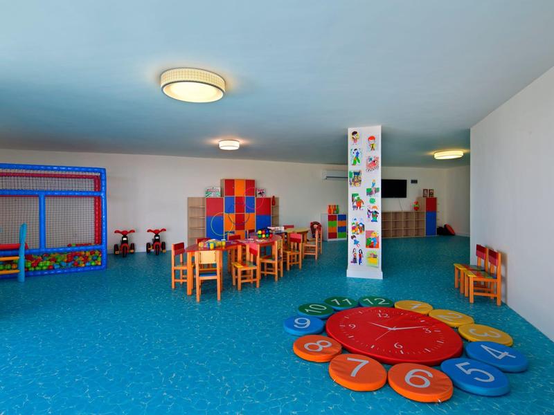 Colorful children's playroom with tables, chairs, and a number-patterned carpet
