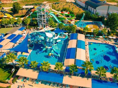 Freizeitpark mit mehreren Wasserrutschen, Becken und grüner Umgebung an sonnigem Tag.