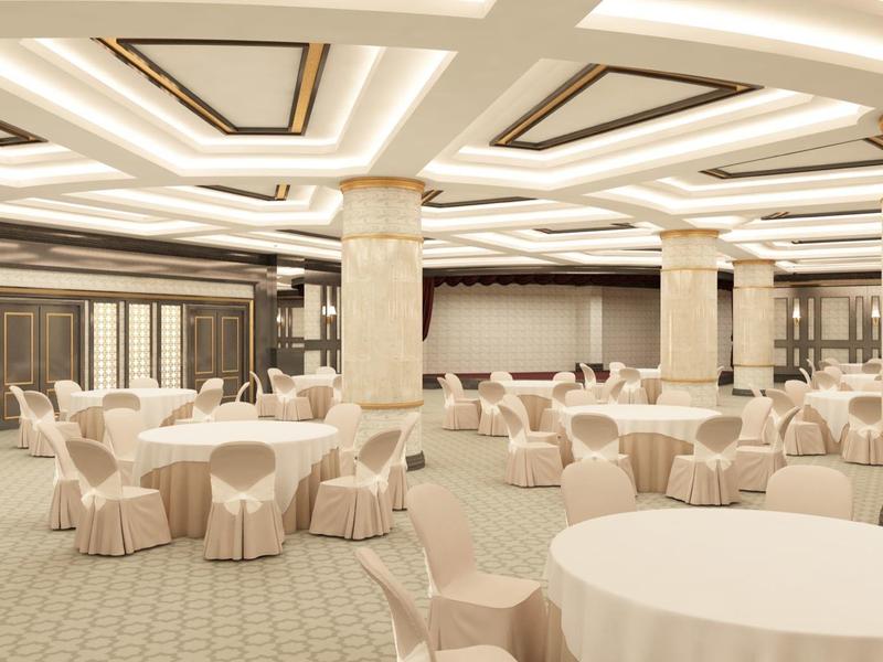 Großer Bankettsaal mit runden Tischen, beigen Stühlen und verzierten Säulen in hellem Farbton.
