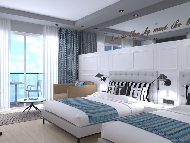 Helles Hotelzimmer mit zwei Einzelbetten, Balkon, modernem Schreibtisch und hellen Vorhängen.