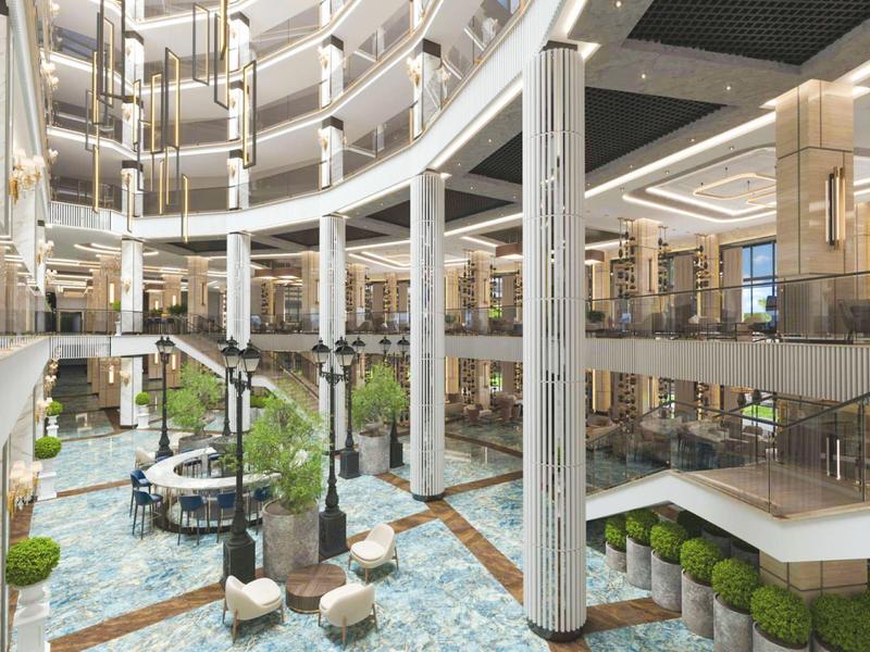 Großzügiges, modernes Atrium mit Marmorfußboden, weißen Säulen und Pflanzenarrangements.