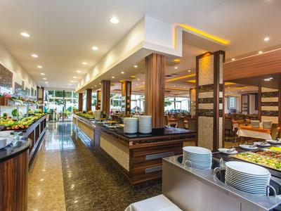 Modernes Buffetrestaurant mit Holzverkleidung, hellen Deckenlichtern und vielfältigen Speisenangebot.