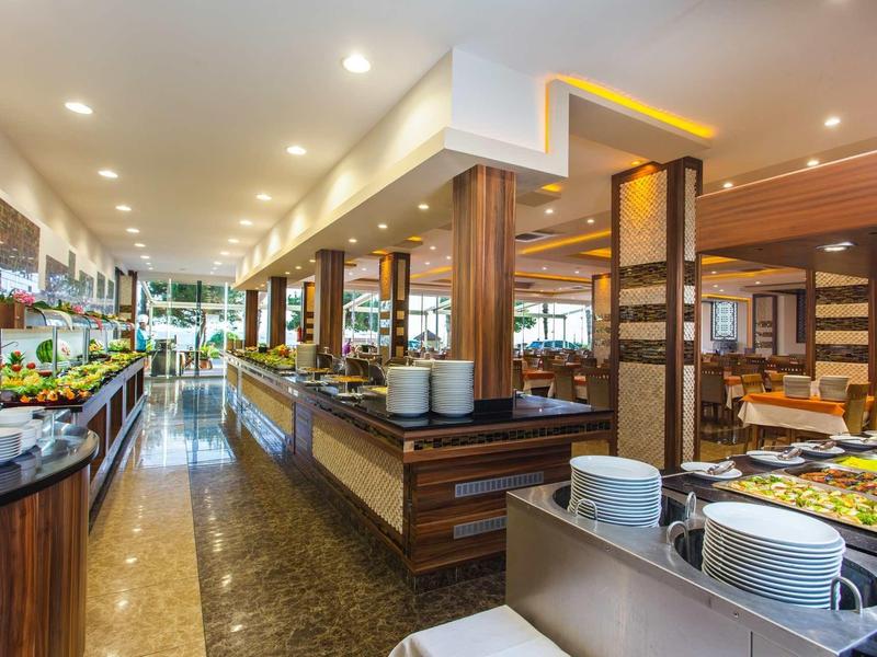 Modernes Buffetrestaurant mit Holzverkleidung, hellen Deckenlichtern und vielfältigen Speisenangebot.