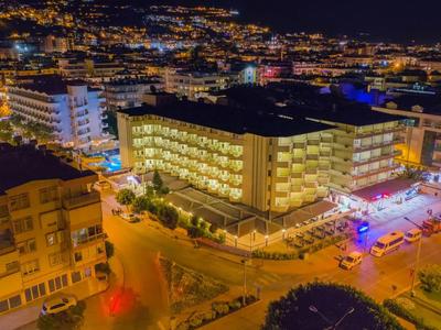 Night city scene with illuminated hotel and streets busy with vehicles