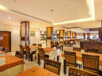 Helles Restaurant mit gedeckten Tischen und Holzmöbeln in einem Hotel.