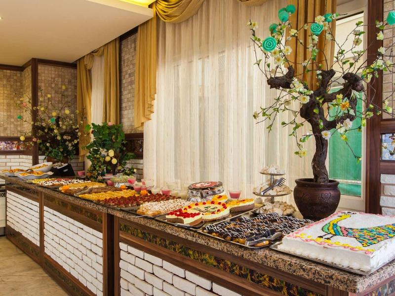 Buffet with various dishes and cakes in an elegantly decorated room.