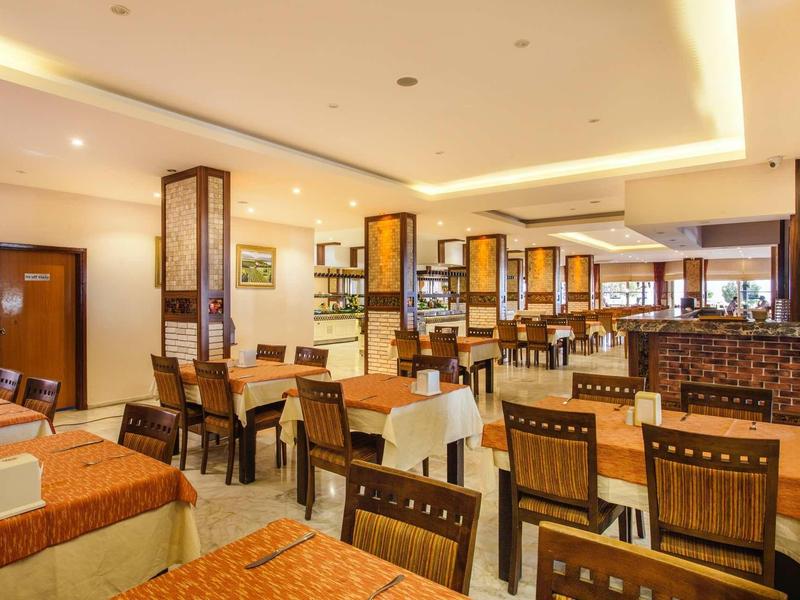 Bright restaurant with set tables and wooden chairs