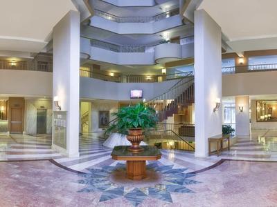 Hall d'hôtel spacieux avec fontaine centrale et décoration végétale.