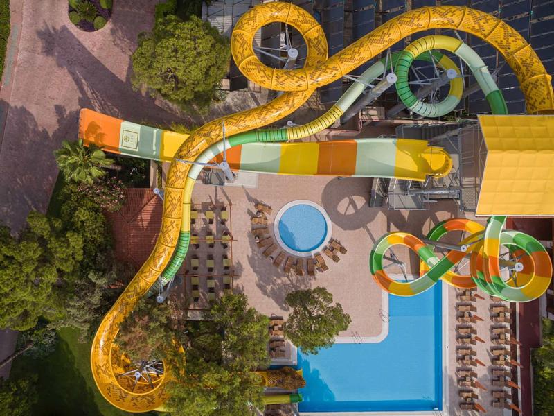 Vue aérienne d'un parc aquatique avec grands toboggans colorés et piscine.