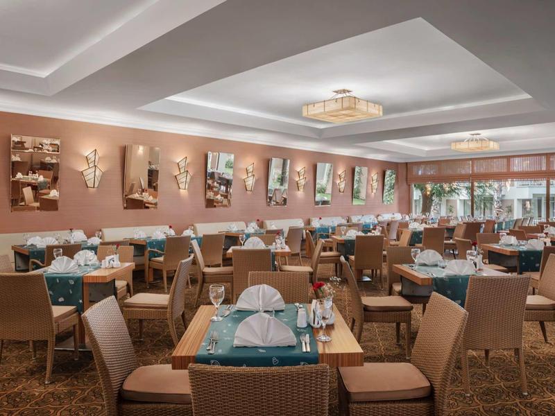 Salle de restaurant avec tables dressées et chaises confortables dans un décor chaleureux.