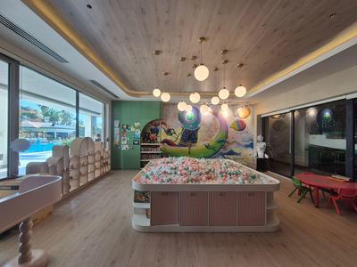 Sala zabaw w hotelu z basenem z piłeczkami, nowoczesnym wystrojem i widokiem na basen na zewnątrz.