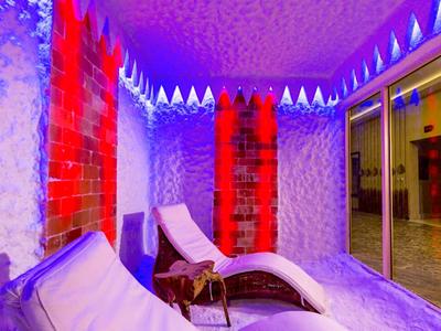 Strefa relaksu z leżakami w pomieszczeniu o kolorowym oświetleniu.