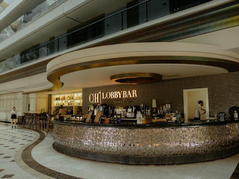 Nowoczesny bar w przestronnym holu hotelowym z marmurową podłogą.