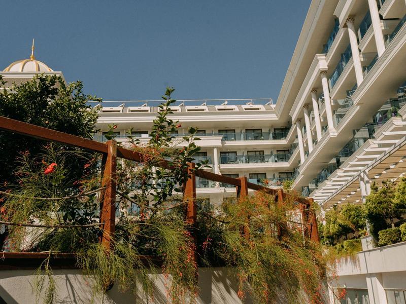 Nowoczesny hotel z drewnianymi balustradami i roślinami pod czystym niebem.