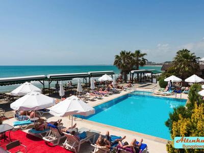 Piscina affollata dell'hotel con lettini, ombrelloni e vista mare