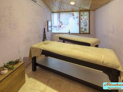 Accogliente sala benessere con due lettini da massaggio e luce soffusa.