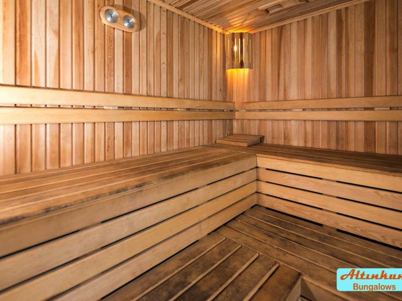 Interno di una sauna tradizionale con panche in legno e illuminazione calda.